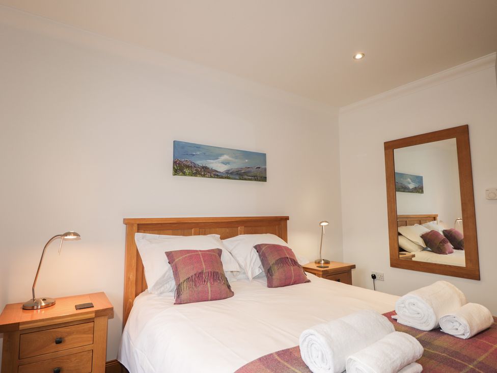 A bedroom with a bed and bedside table at Little Chestnut in Muir of Ord