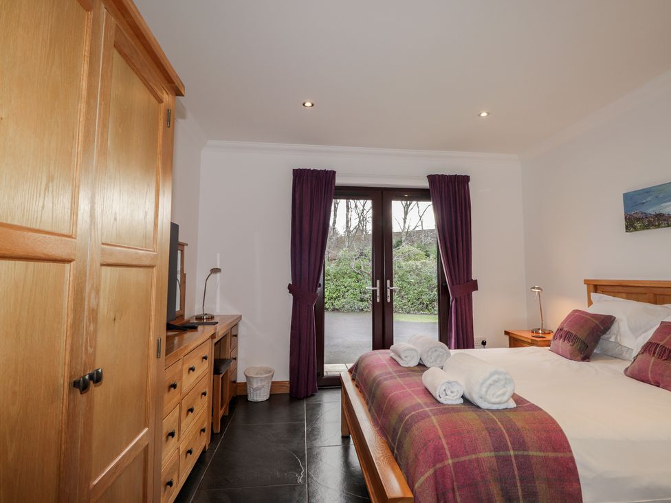 A bedroom with a bed and television at Little Chestnut Muir of Ord