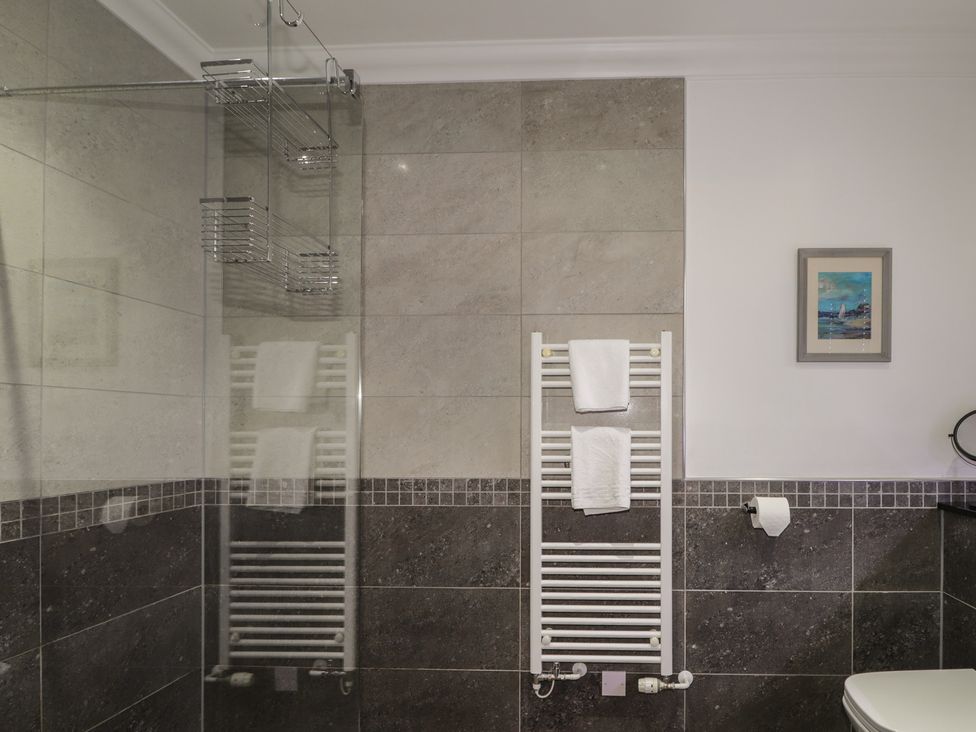 A bathroom with a shower and towel rail at Little Chestnut Muir of Ord