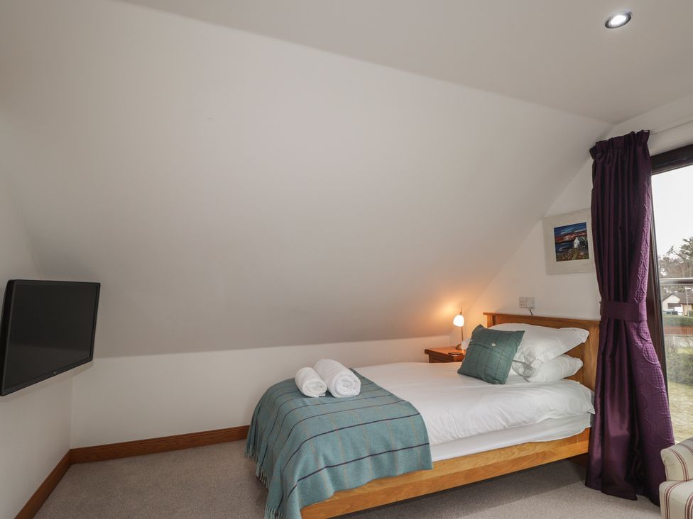 A bedroom with a bed and TV at Little Chestnut in Muir of Ord