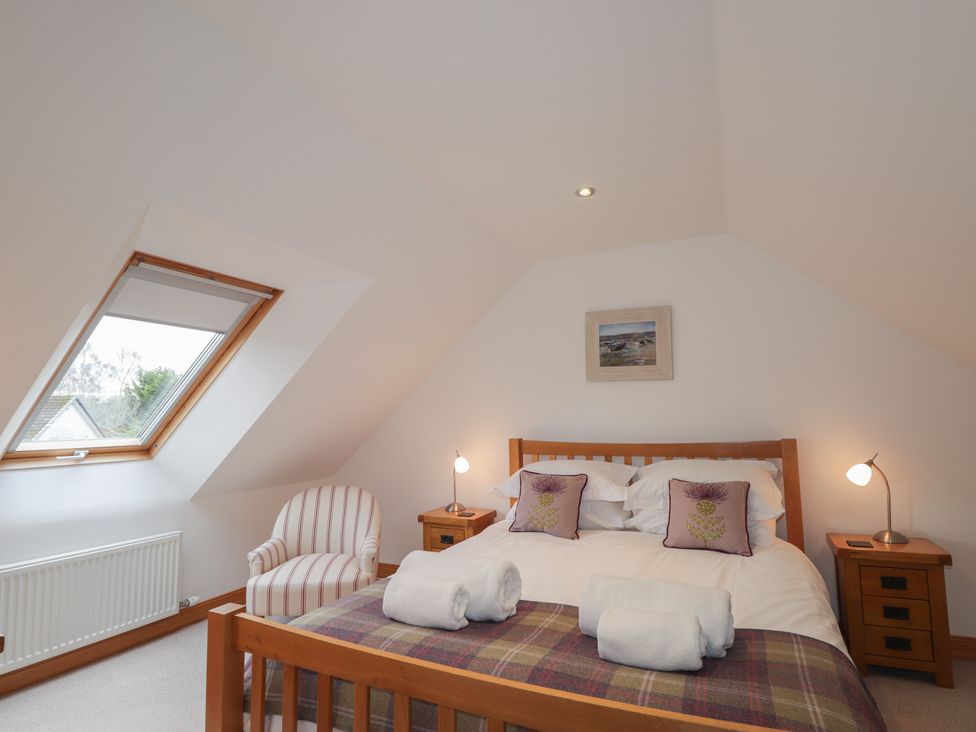 A bedroom with a bed and bedside tables at Little Chestnut in Muir of Ord
