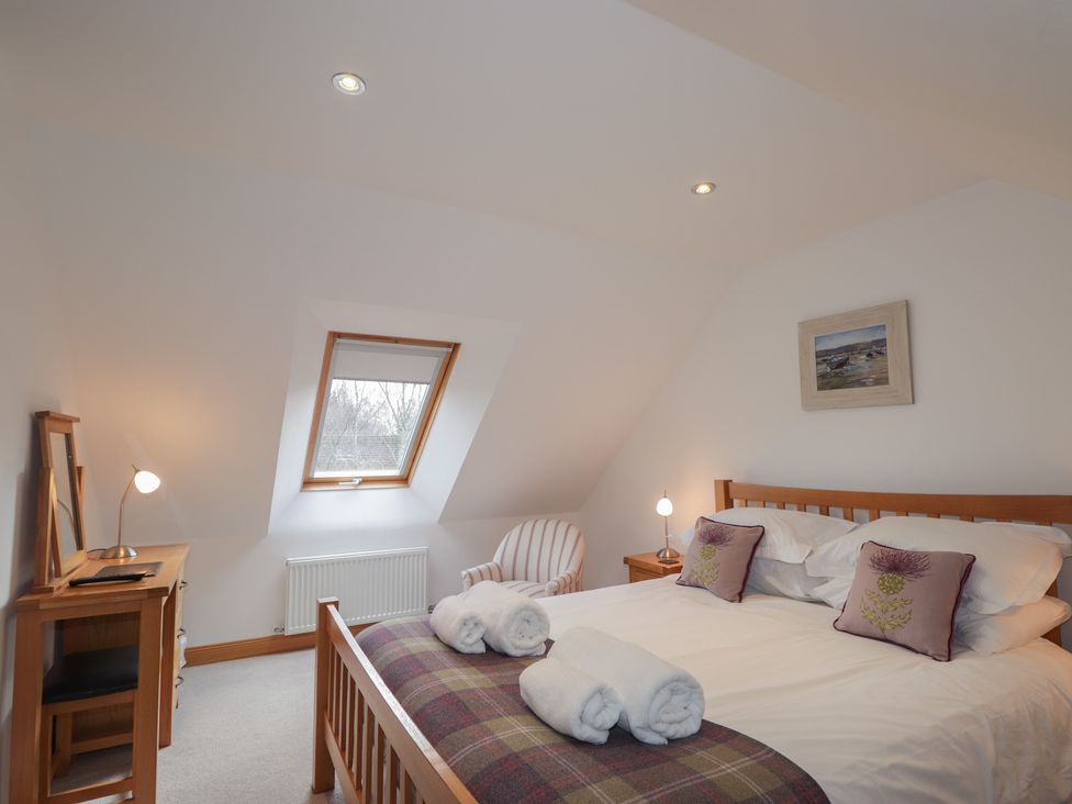 A bedroom with a bed and desk at Little Chestnut in Muir of Ord