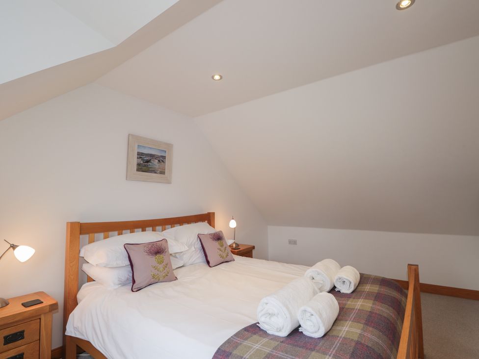 A bedroom with a bed and towels at Little Chestnut in Muir of Ord