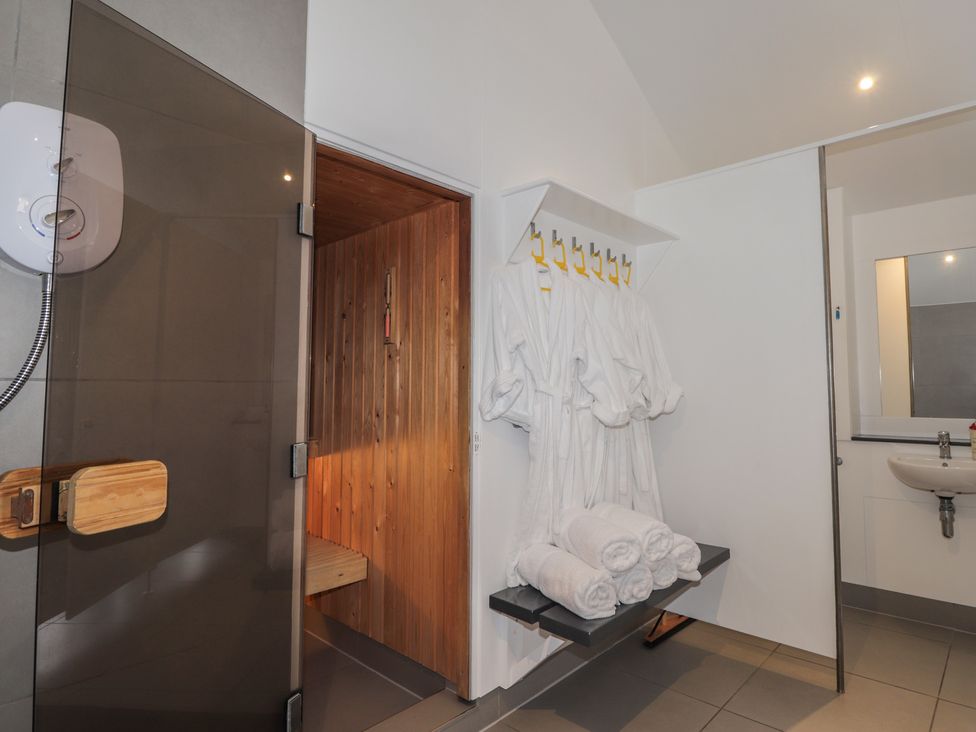 A bathroom with a sauna and towels at Little Chestnut in Muir of Ord