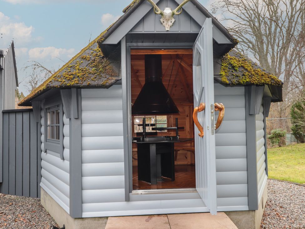 A cabin with an open door showing furniture inside at Little Chestnut in Muir of Ord