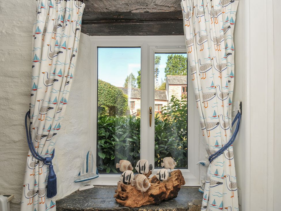 A living room with a window and curtains at Wagtail Cottage East Taphouse