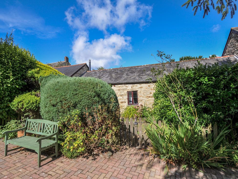 A garden with a bench and plants at Wagtail Cottage East Taphouse