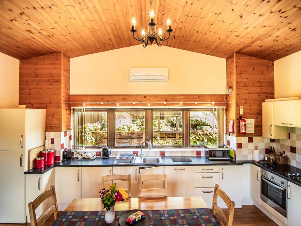A kitchen with a table and chairs at Sycamore Lodge Nantmel near Rhayader