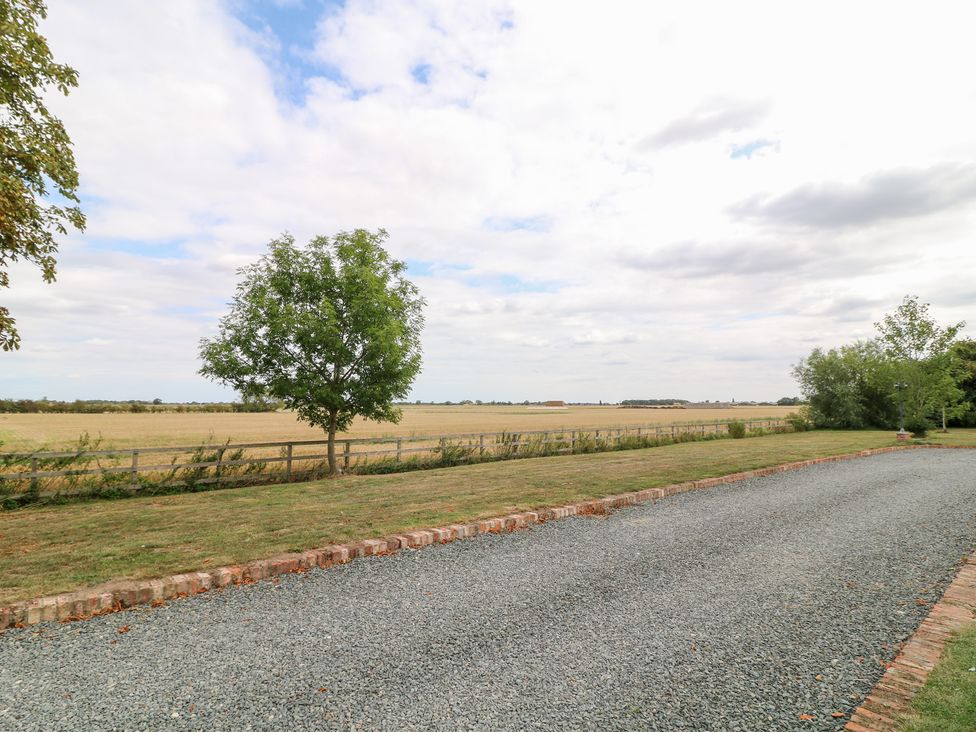 An outdoor view featuring a gravel driveway and a tree at Jake's Cottage in Langrick near Boston