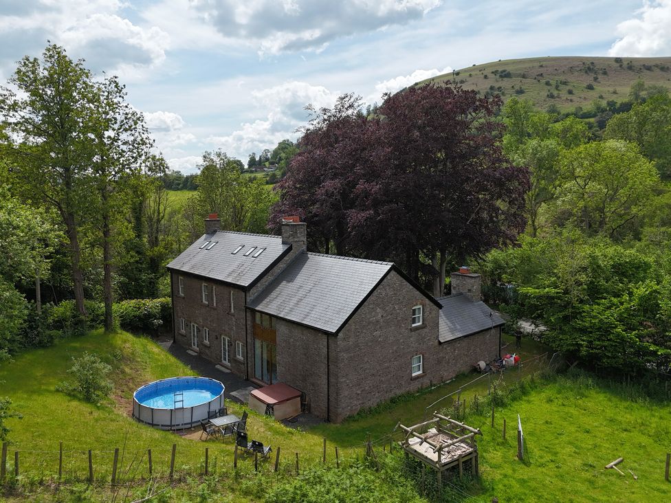 A house with a pool in an outdoor area at Plas Glyndwr in Crickhowell