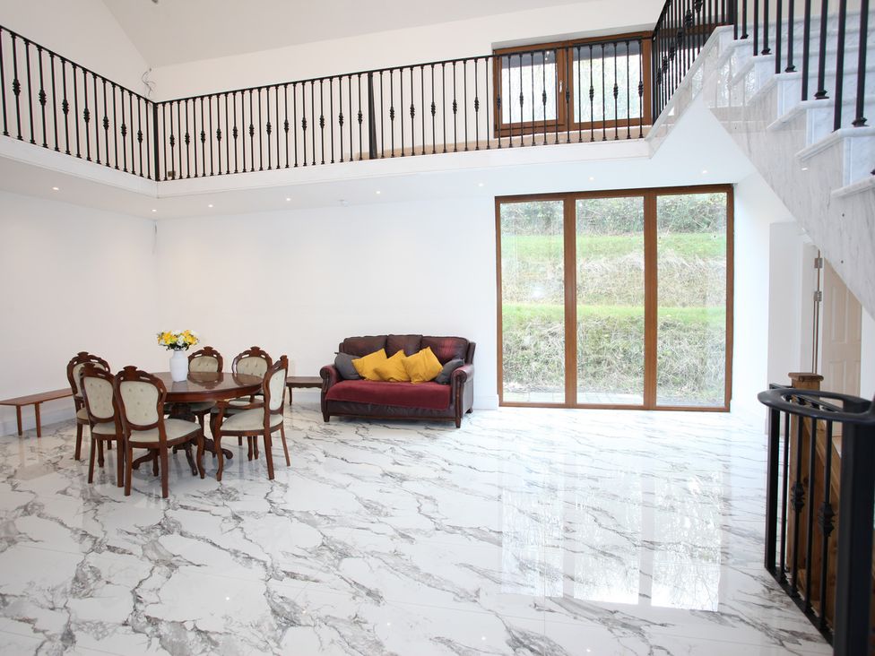 A living room with a sofa and dining table at Plas Glyndwr in Crickhowell