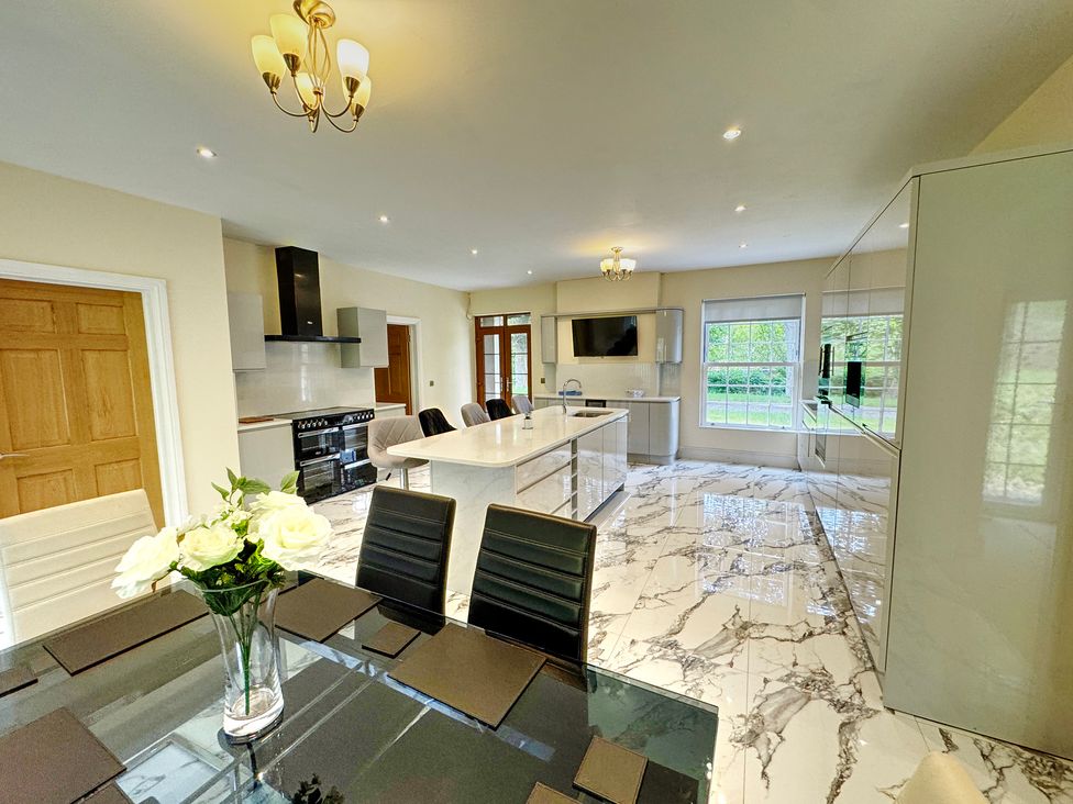 A kitchen with an island and dining area at Plas Glyndwr in Crickhowell