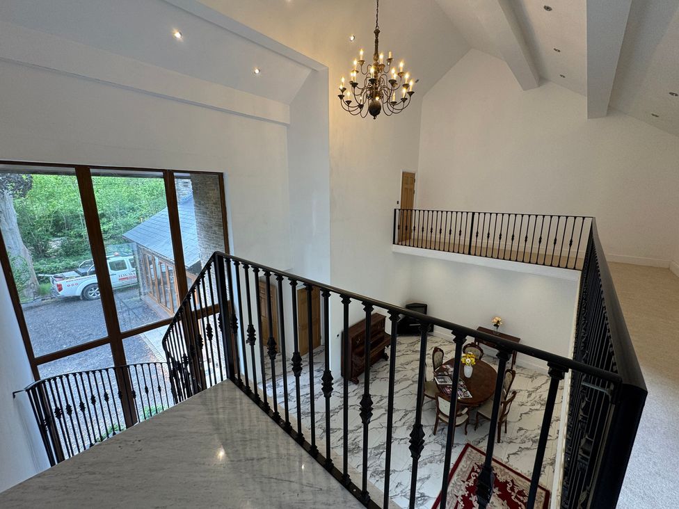 An open space with a chandelier and furniture at Plas Glyndwr Crickhowell