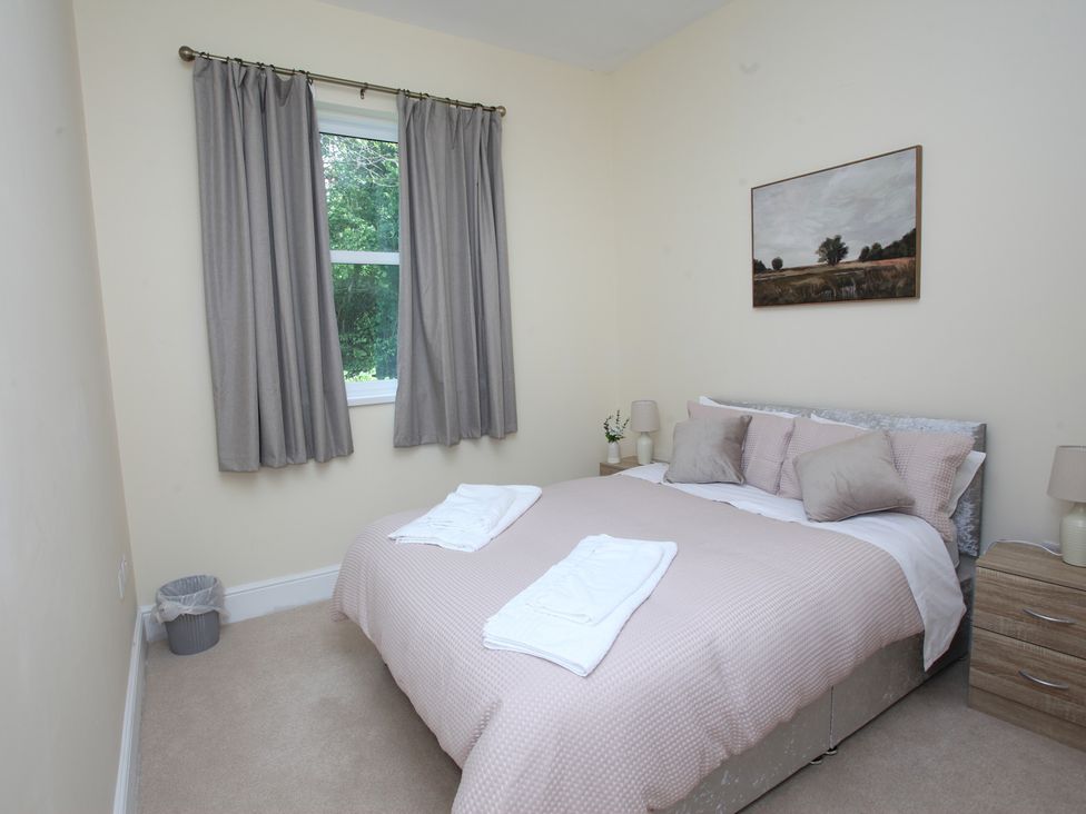 A bedroom with a bed and bedside table at Plas Glyndwr in Crickhowell
