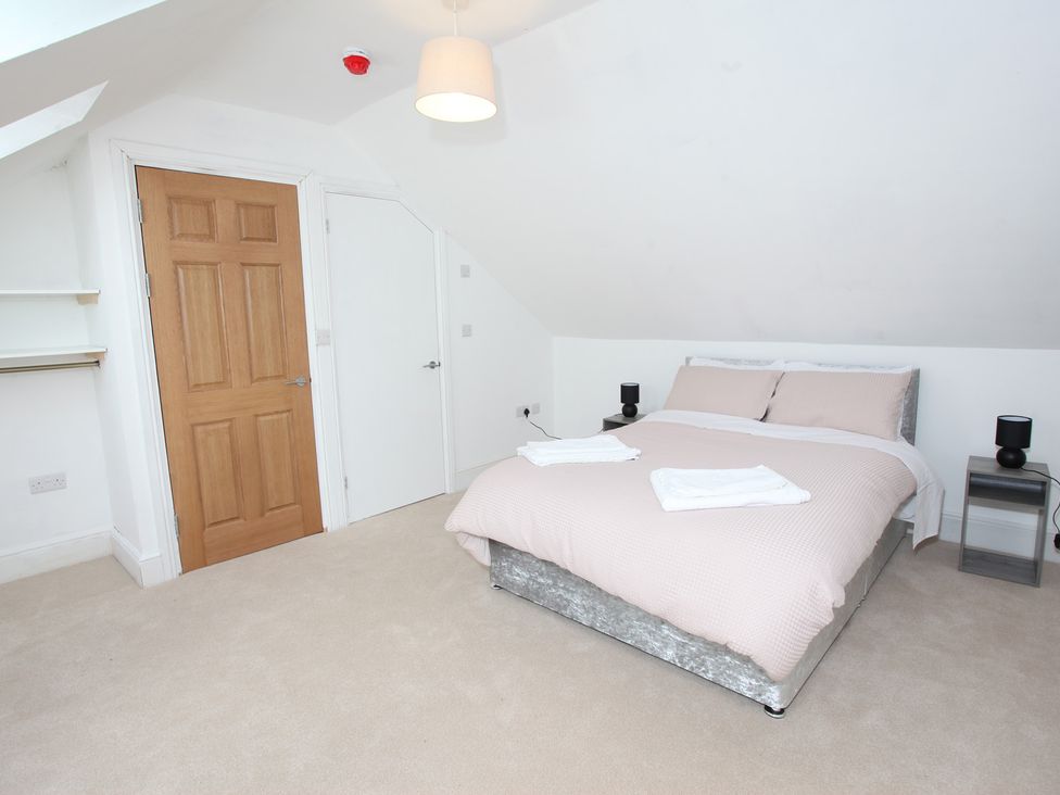 A bedroom with a bed and bedside tables at Plas Glyndwr in Crickhowell