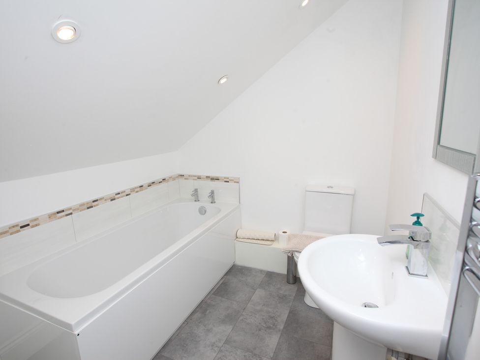 A bathroom with a bath tub and sink at Plas Glyndwr in Crickhowell