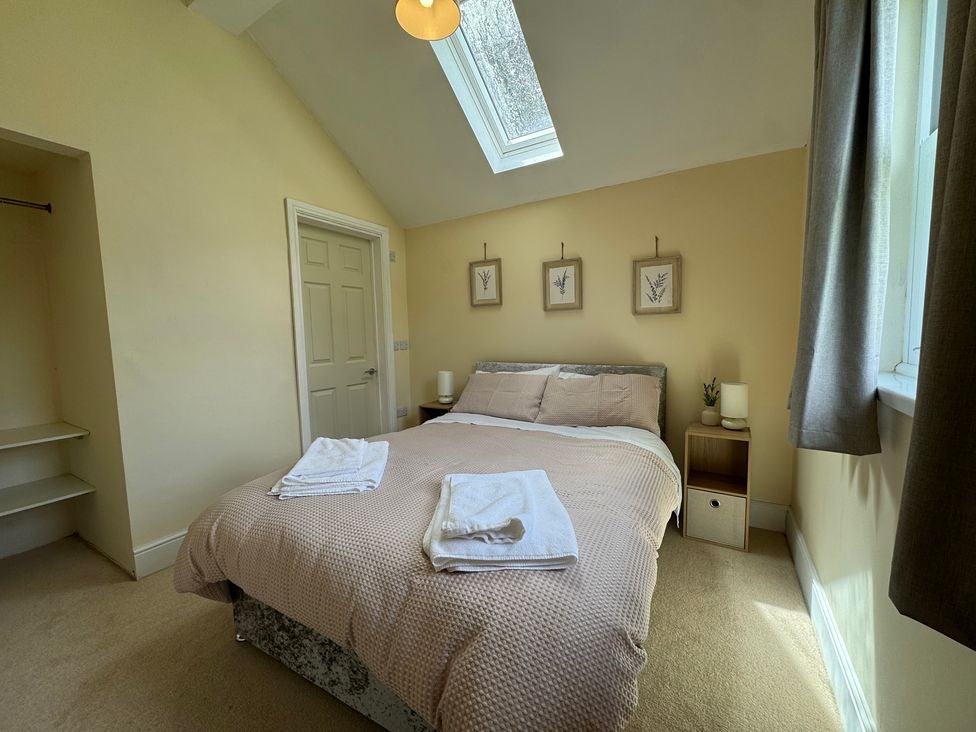 A bedroom with a bed and nightstand at Plas Glyndwr in Crickhowell