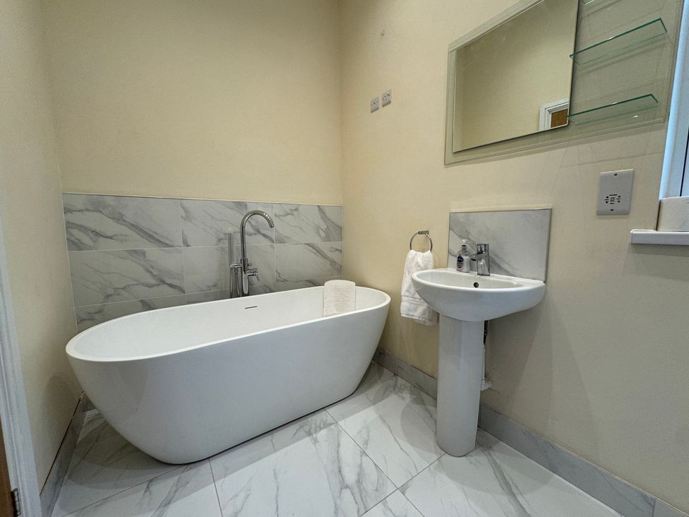 A bathroom with a bathtub and sink at Plas Glyndwr Crickhowell