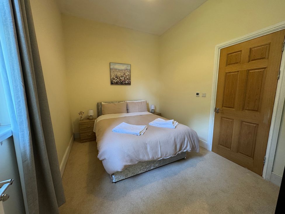A bedroom with a bed and bedside tables at Plas Glyndwr in Crickhowell