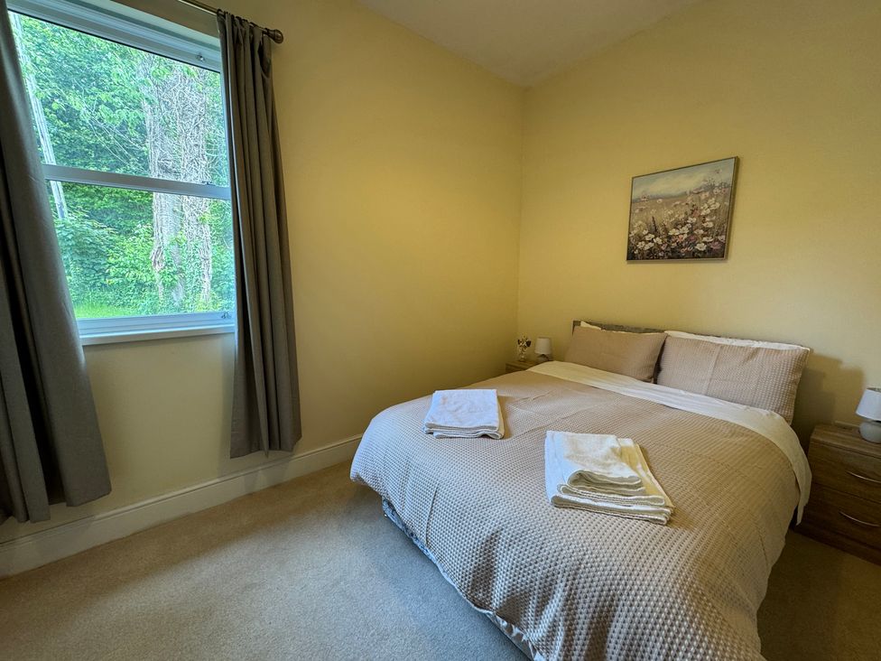 A bedroom with a double bed and window at Plas Glyndwr in Crickhowell