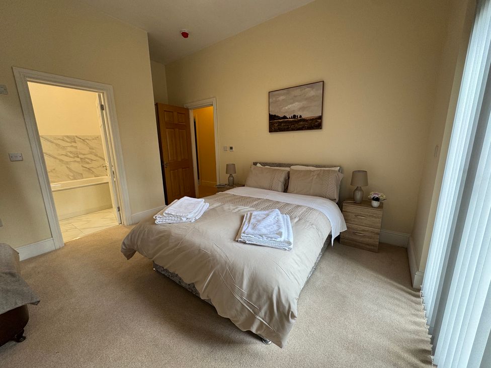A bedroom with a bed and nightstand at Plas Glyndwr in Crickhowell