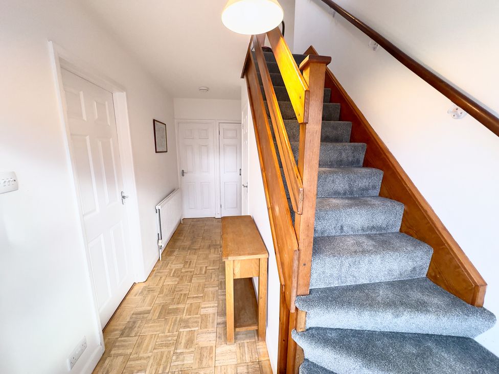A hallway with stairs and a table at 38 Dale End Brancaster Staithe near Burnham Market