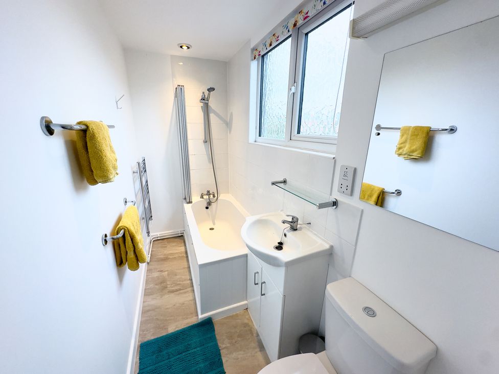 A bathroom with a bathtub, toilet, and sink at 38 Dale End Brancaster Staithe near Burnham Market