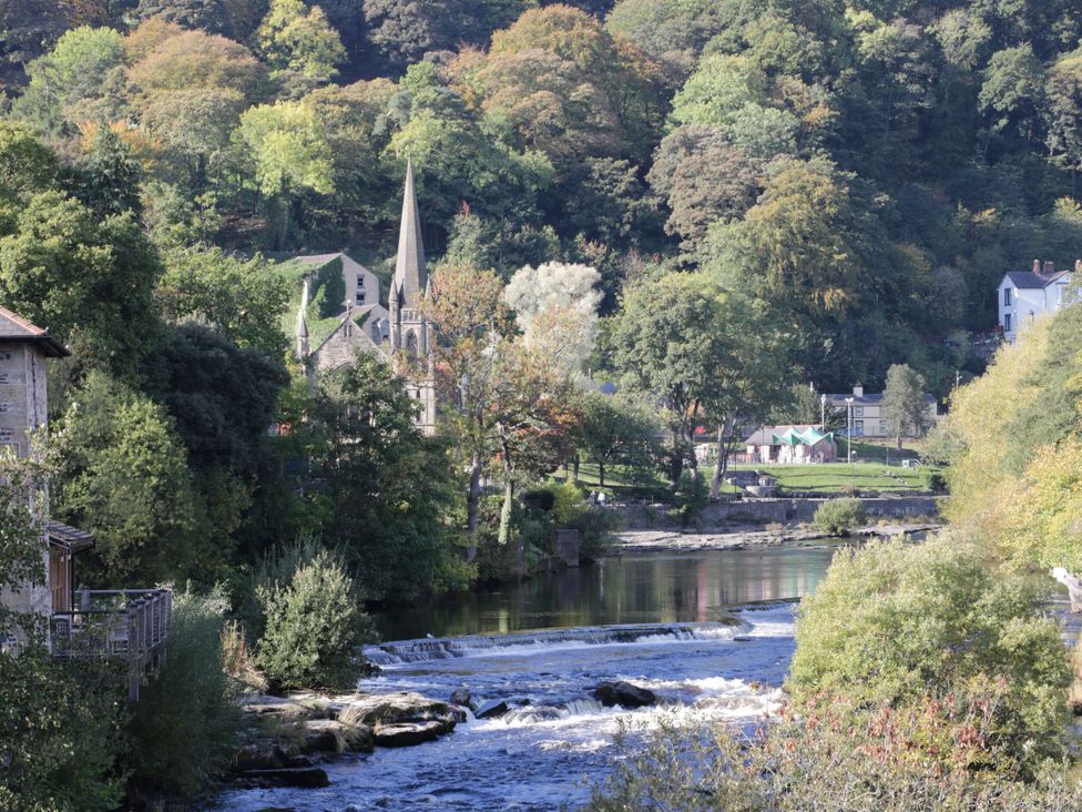 A view of a river and church surrounded by trees at Penymaes Bronygarth near Chirk