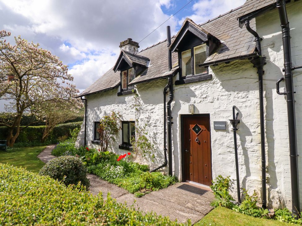 A cottage exterior with flowers and a path at Penymaes Bronygarth near Chirk