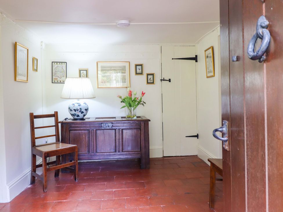 An entryway with a lamp and chair at Penymaes in Bronygarth near Chirk