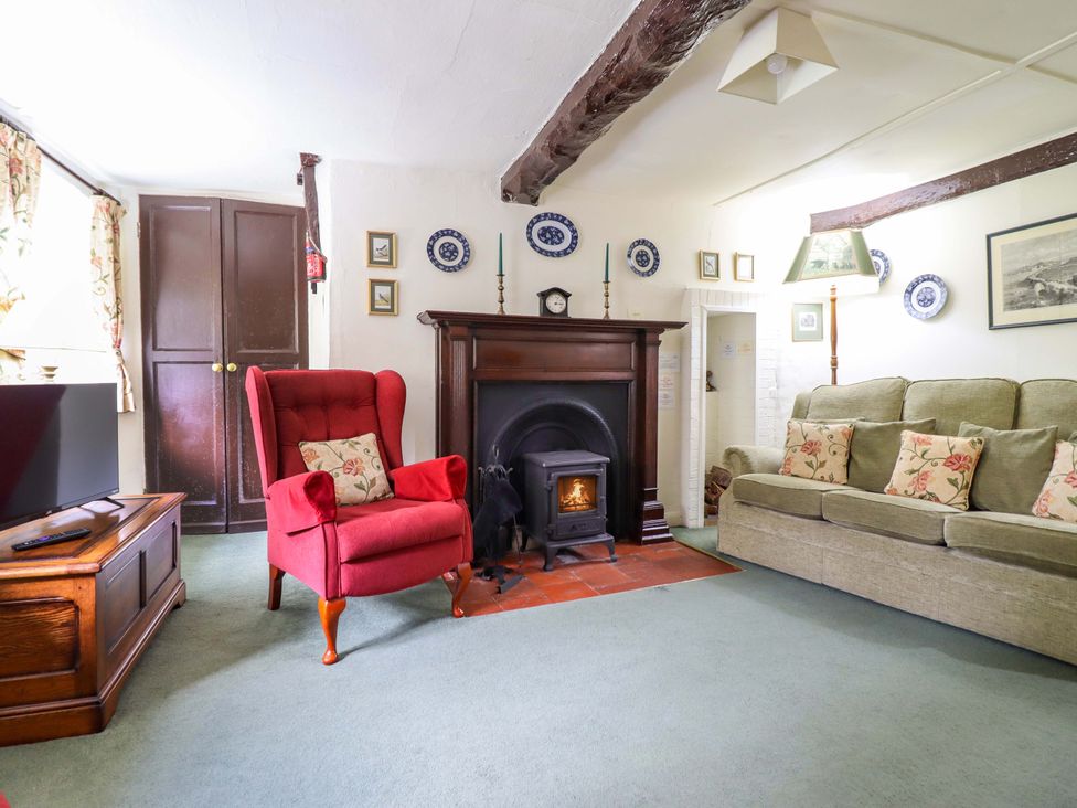 A living room with a fireplace and sofa at Penymaes in Bronygarth near Chirk