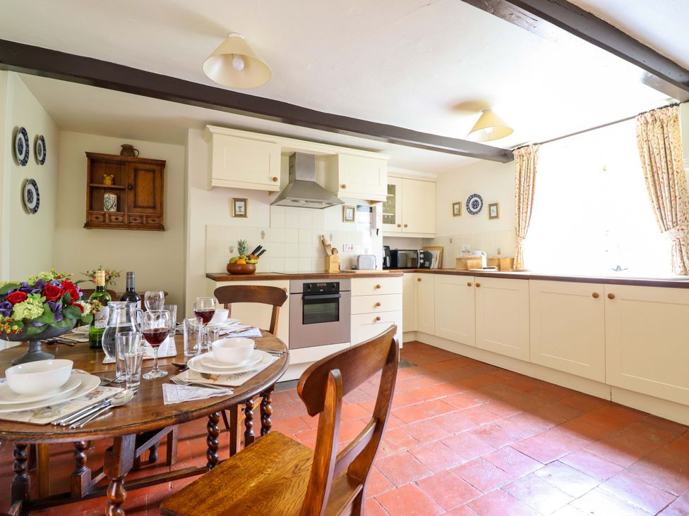 A kitchen with a dining area and various kitchen appliances at Penymaes in Bronygarth near Chirk