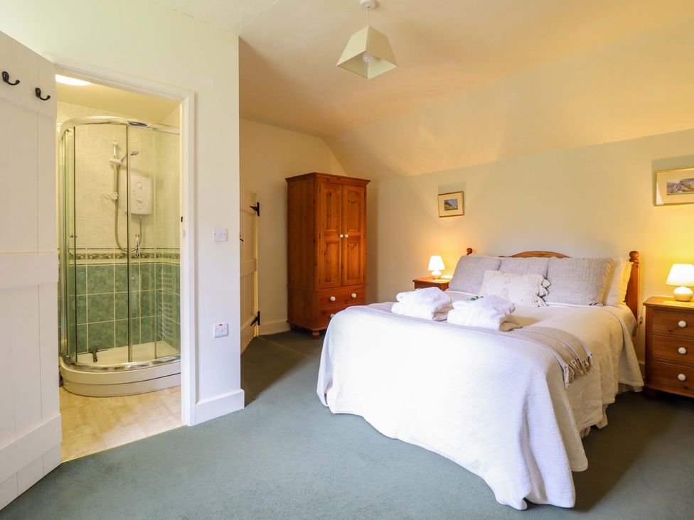 A bedroom with a bed and shower cubicle at Penymaes Bronygarth near Chirk