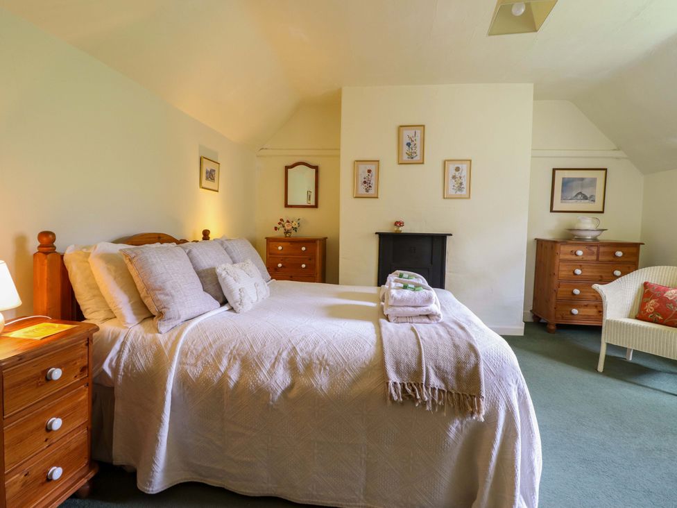 A bedroom with a bed and furniture at Penymaes in Bronygarth near Chirk