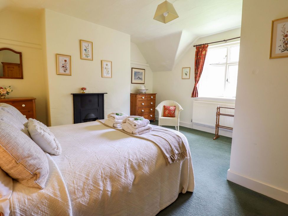 A bedroom with a bed and dresser at Penymaes Bronygarth near Chirk