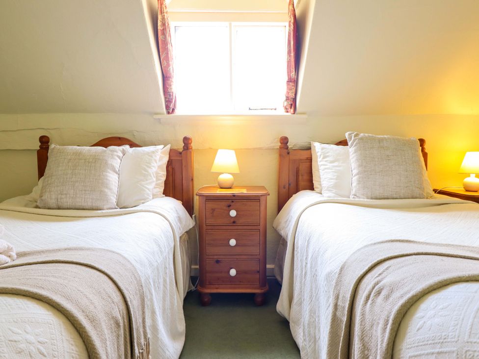 A bedroom with two beds and a nightstand at Penymaes Bronygarth near Chirk