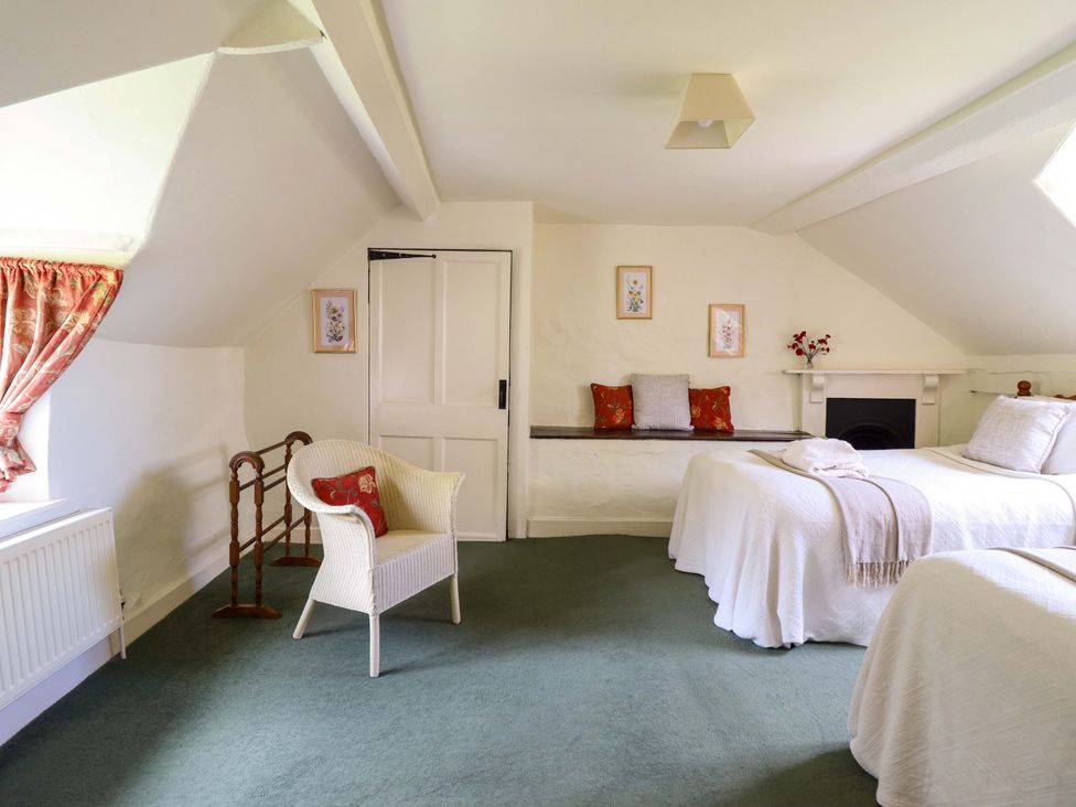 A bedroom with two beds and a chair at Penymaes Bronygarth near Chirk