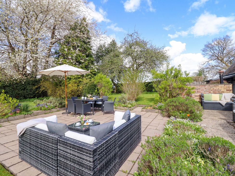 An outdoor seating area with a table and umbrella at Penymaes Bronygarth near Chirk
