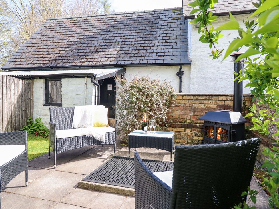 A patio area with seating and a wood stove at Penymaes near Bronygarth