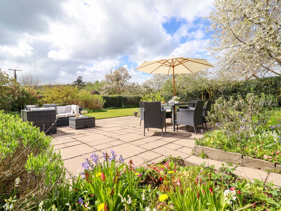 A garden with patio furniture and flowers at Penymaes in Bronygarth near Chirk