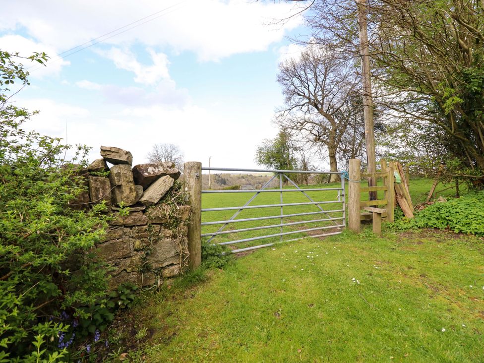 An outdoor area with a gate and stone wall at Penymaes near Bronygarth