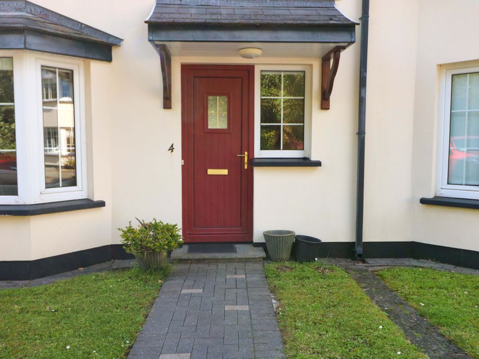 A front entrance with a red door and windows at No. 4 Lansdowne Village Kenmare, The Ring of Kerry, County Kerry