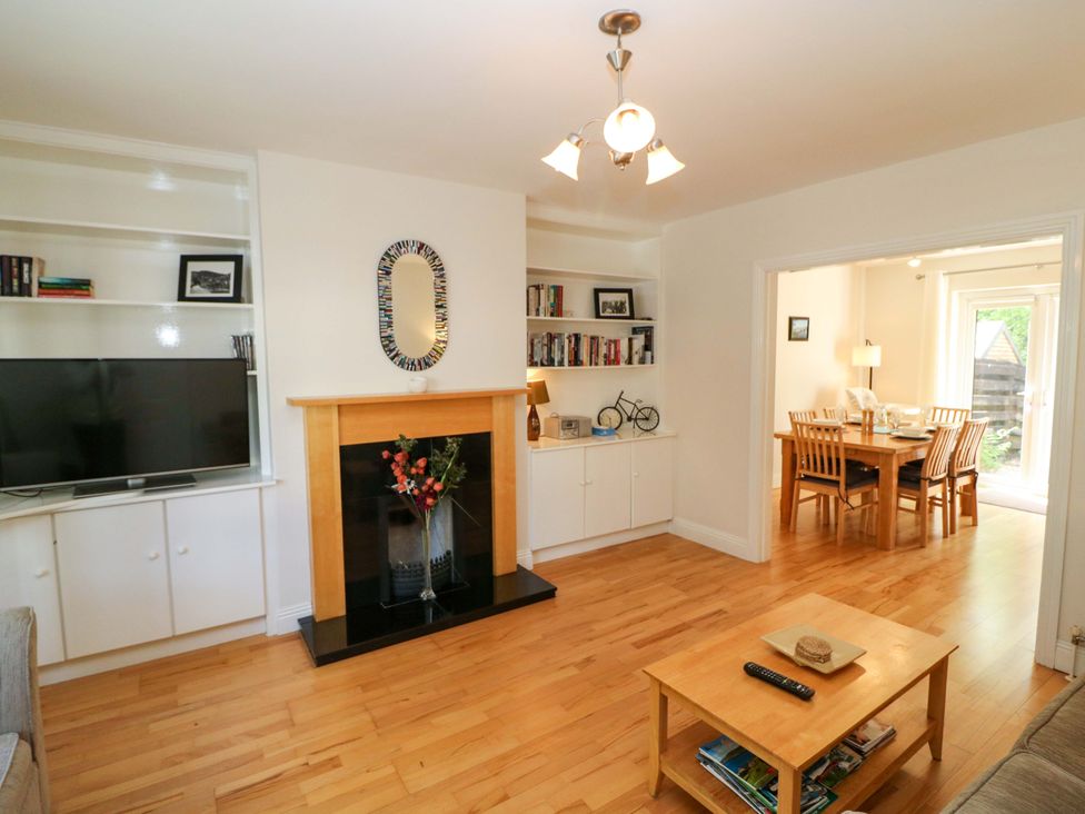 A living room with a fireplace and a dining area at No. 4 Lansdowne Village Kenmare, The Ring of Kerry, County Kerry