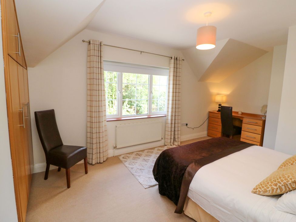 A bedroom with a bed, desk, chair, and window at No. 4 Lansdowne Village, Kenmare, The Ring of Kerry, County Kerry
