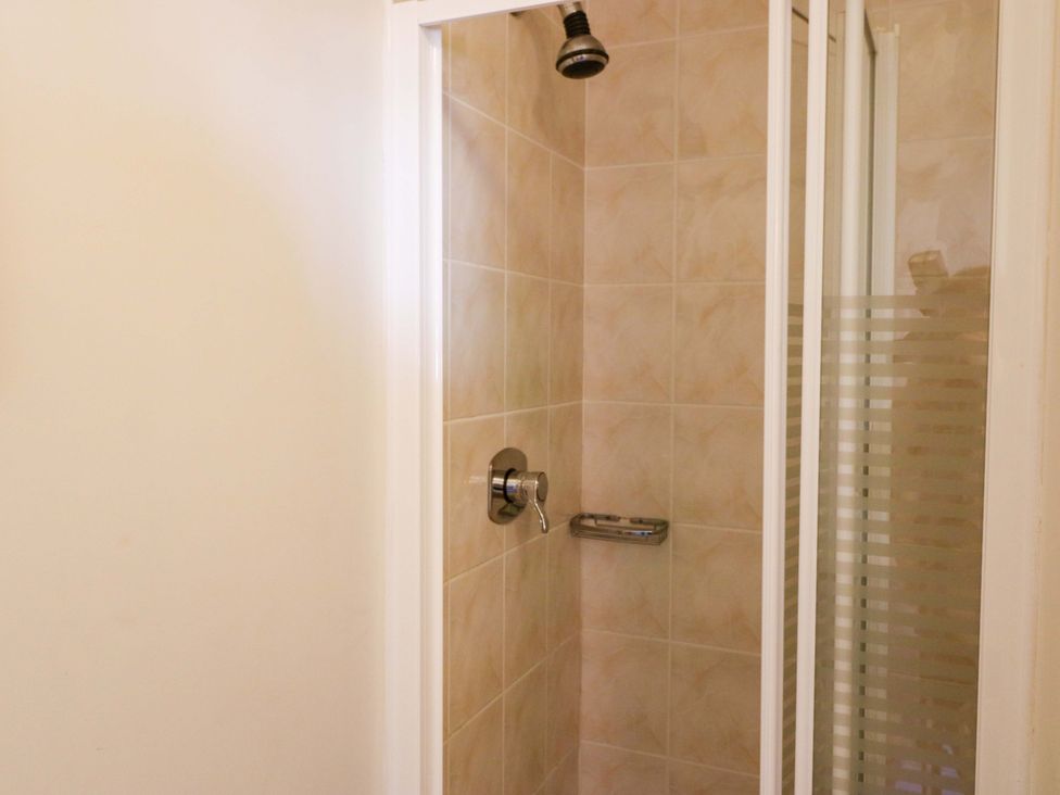 A shower with a glass door and tiled walls at No. 4 Lansdowne Village, Kenmare, The Ring of Kerry, County Kerry
