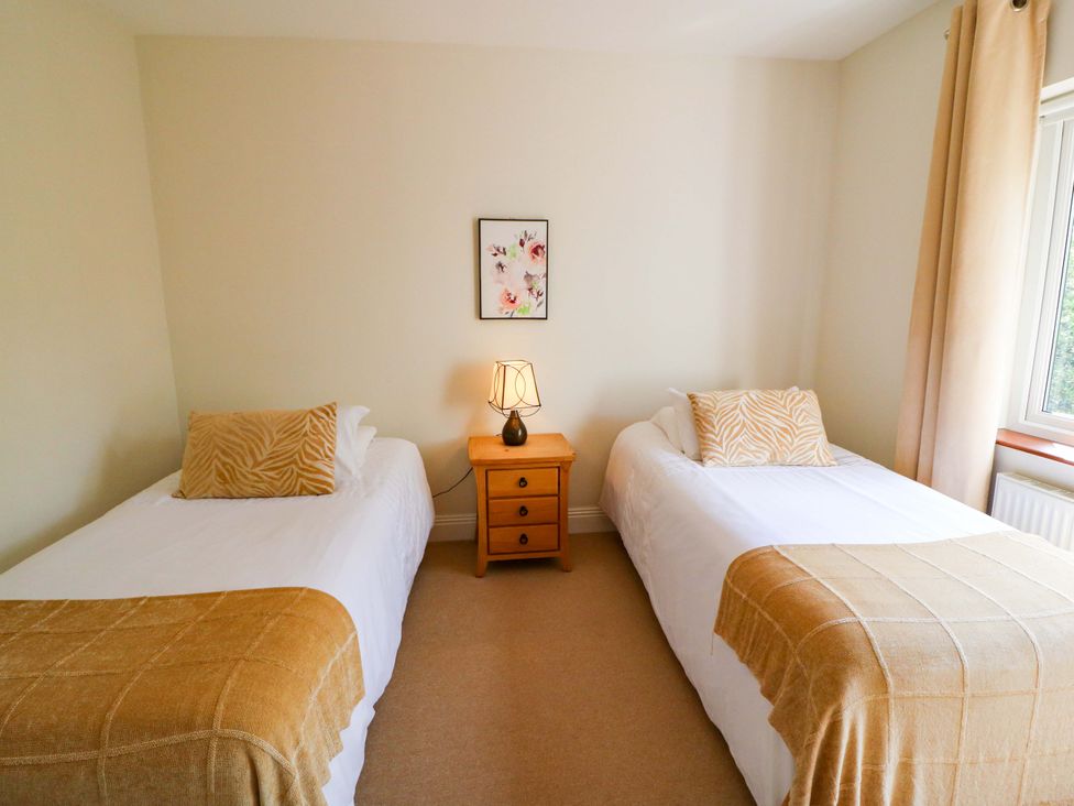 A bedroom with two single beds and a nightstand at No. 4 Lansdowne Village, Kenmare, The Ring of Kerry, County Kerry