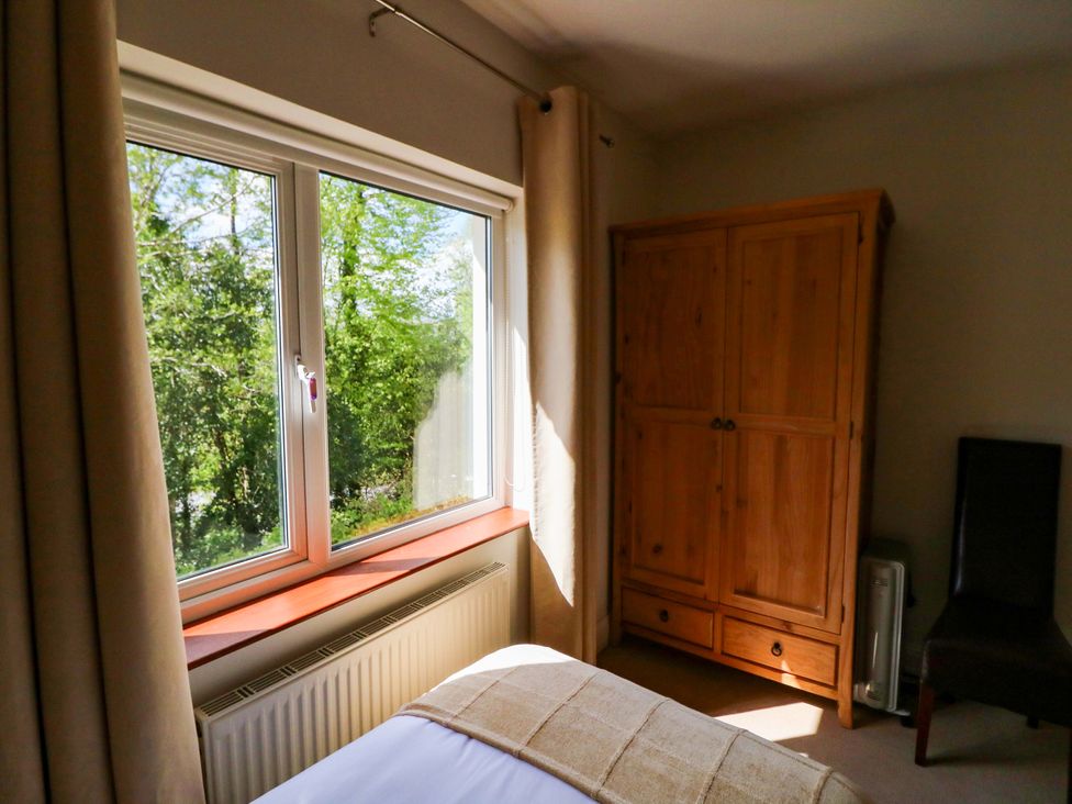 A bedroom with a window, wardrobe and chair at No. 4 Lansdowne Village, Kenmare, The Ring of Kerry, County Kerry