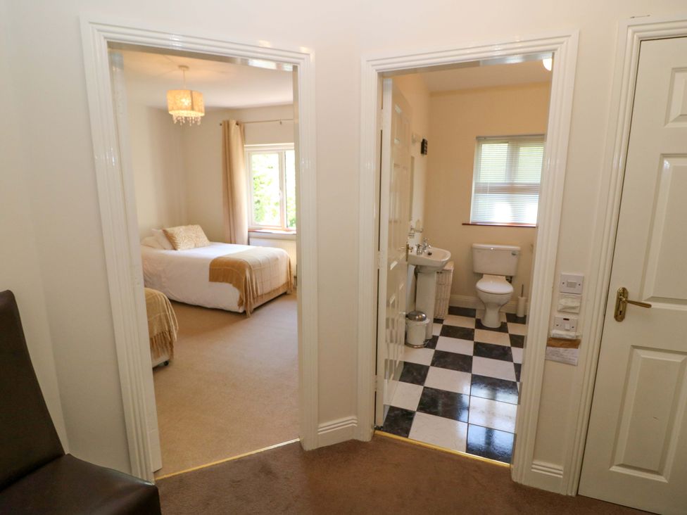 A bedroom with a bed and a bathroom with a toilet at No. 4 Lansdowne Village, Kenmare, The Ring of Kerry, County Kerry