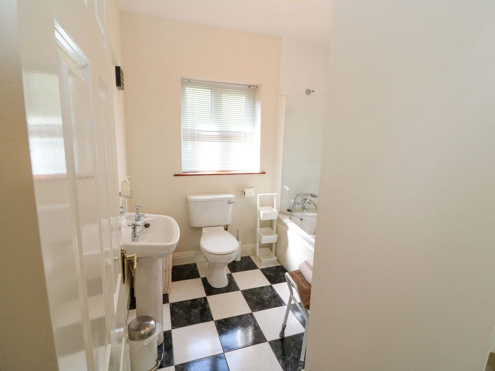 A bathroom with a sink, toilet, window, and bathtub at No. 4 Lansdowne Village, Kenmare, The Ring of Kerry, County Kerry