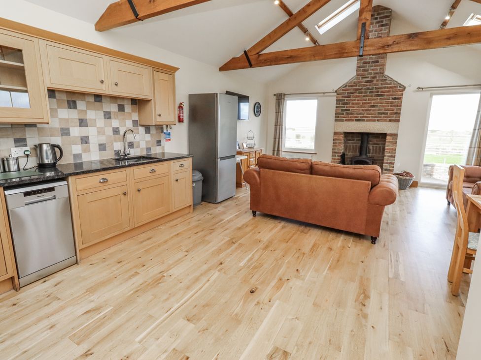 A kitchen with appliances and seating area at Grey Croft in Embleton